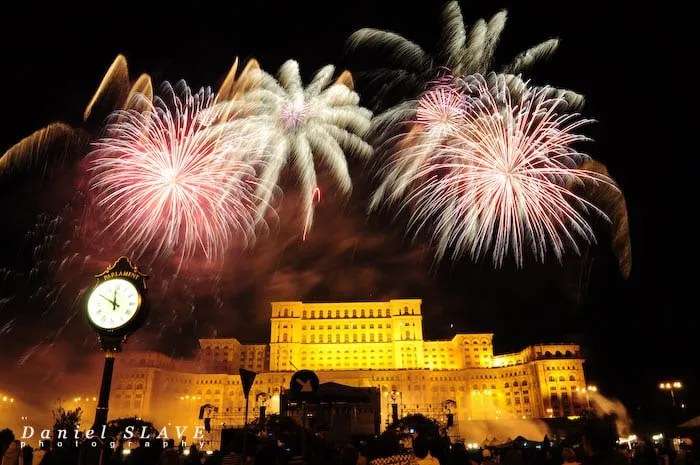 Artificii lumineaza cerul deasupra Palatului Parlamentului din Bucuresti.