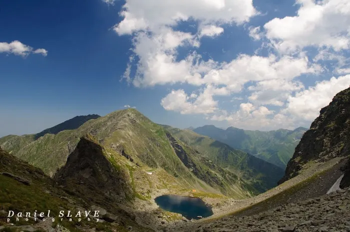 Un lac glaciar se vede într-o vale stâncoasă din Munții Făgăraș.