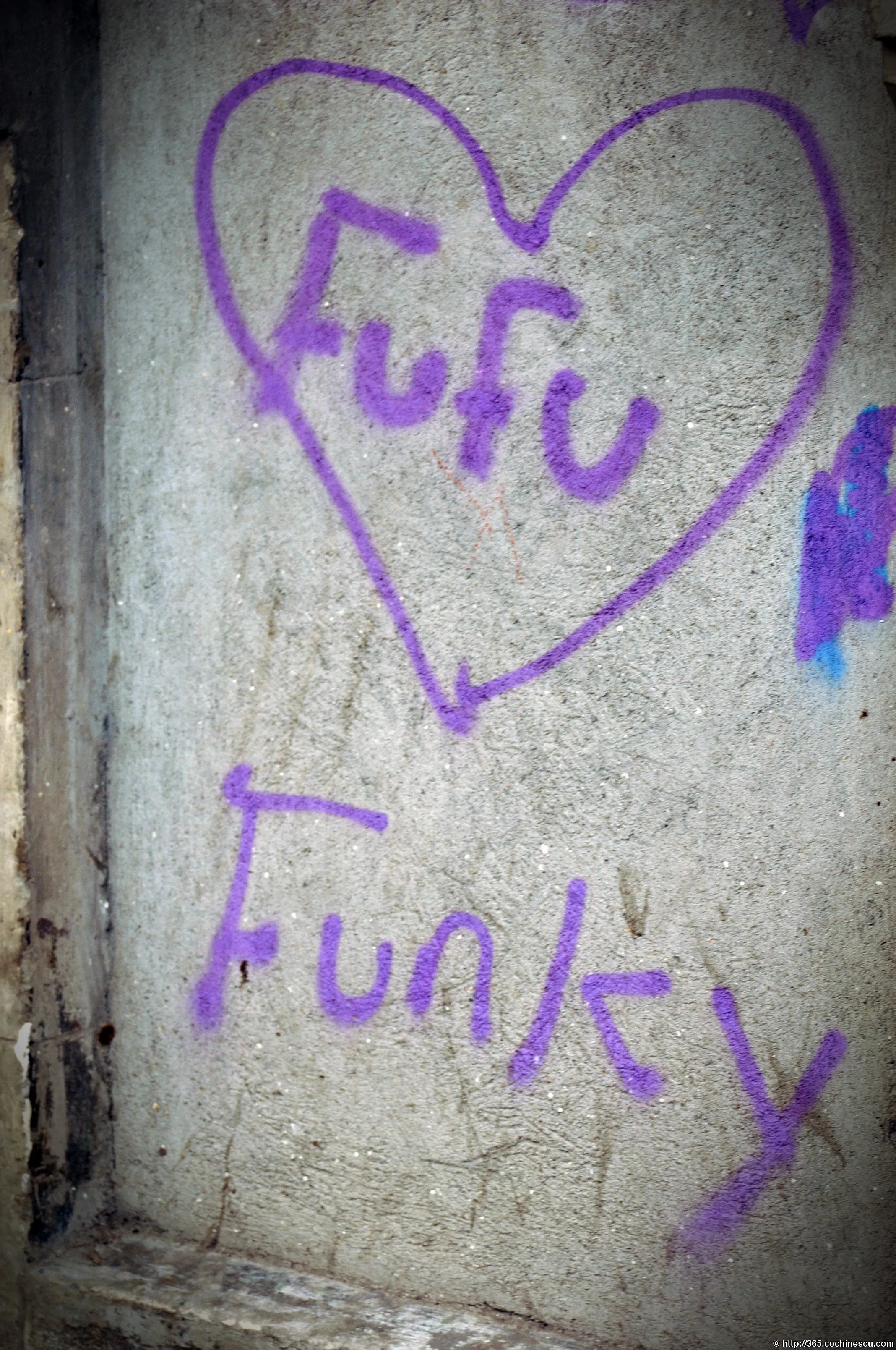 Un graffiti mov cu numele Fufu este desenat intr-o inima pe un perete.