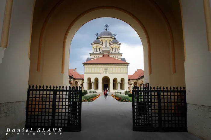 Catedrala Reîntregirii din Alba Iulia este încadrată de bolta porții și de grilajele deschise.