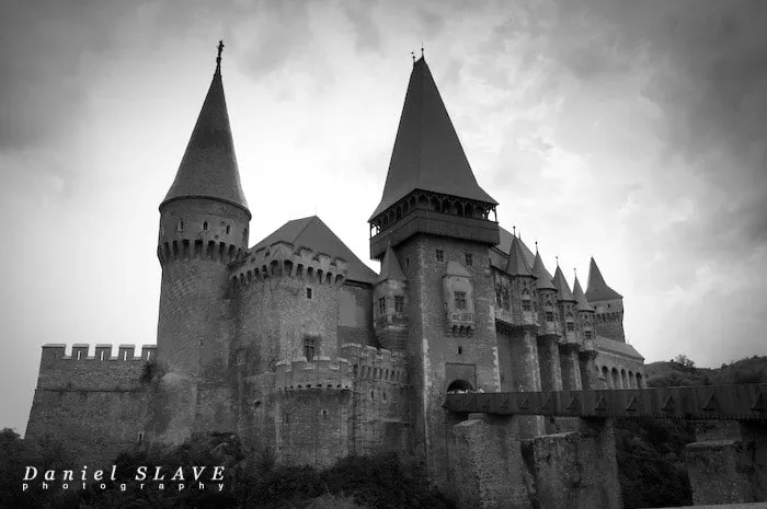 Castelul Corvinilor și podul său de acces sunt surprinse într-o fotografie alb-negru.