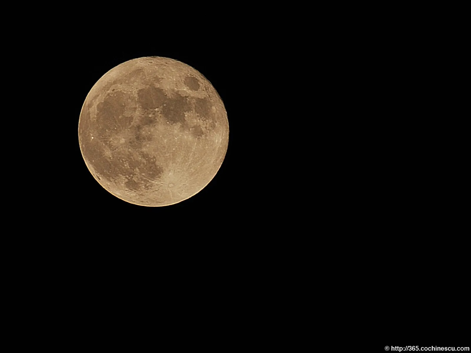 Luna plina este fotografiata pe cerul negru.
