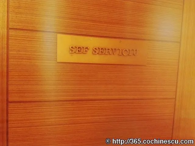 Pe o usa din lemn este montata o placuta pe care scrie «SEF SERVICIU».