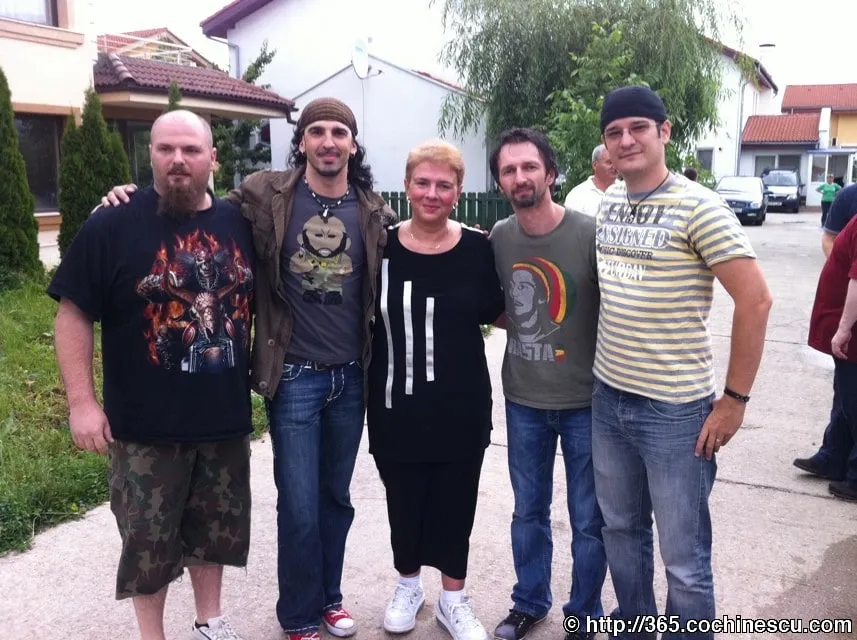 Patru membri ai trupei Hara o inconjoara pe Teo Trandafir intr-o fotografie de grup.